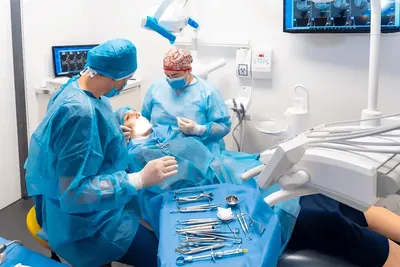 Echipă de chirurgie dentară și instrumente pregătite pentru tratament.